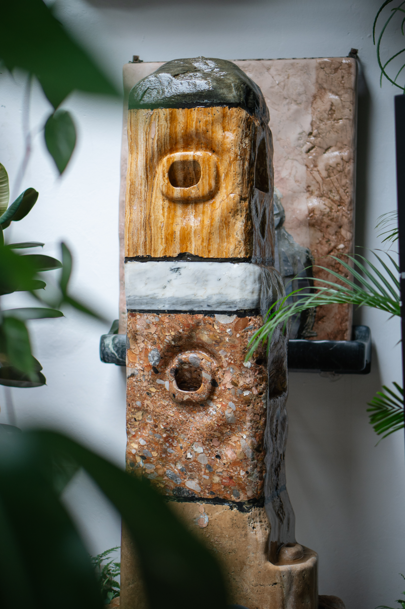 Brunnen aus unterschiedlichen Steinen gestapelt in Form eines recheckigen Resalits, Wasser fließt über die Steine