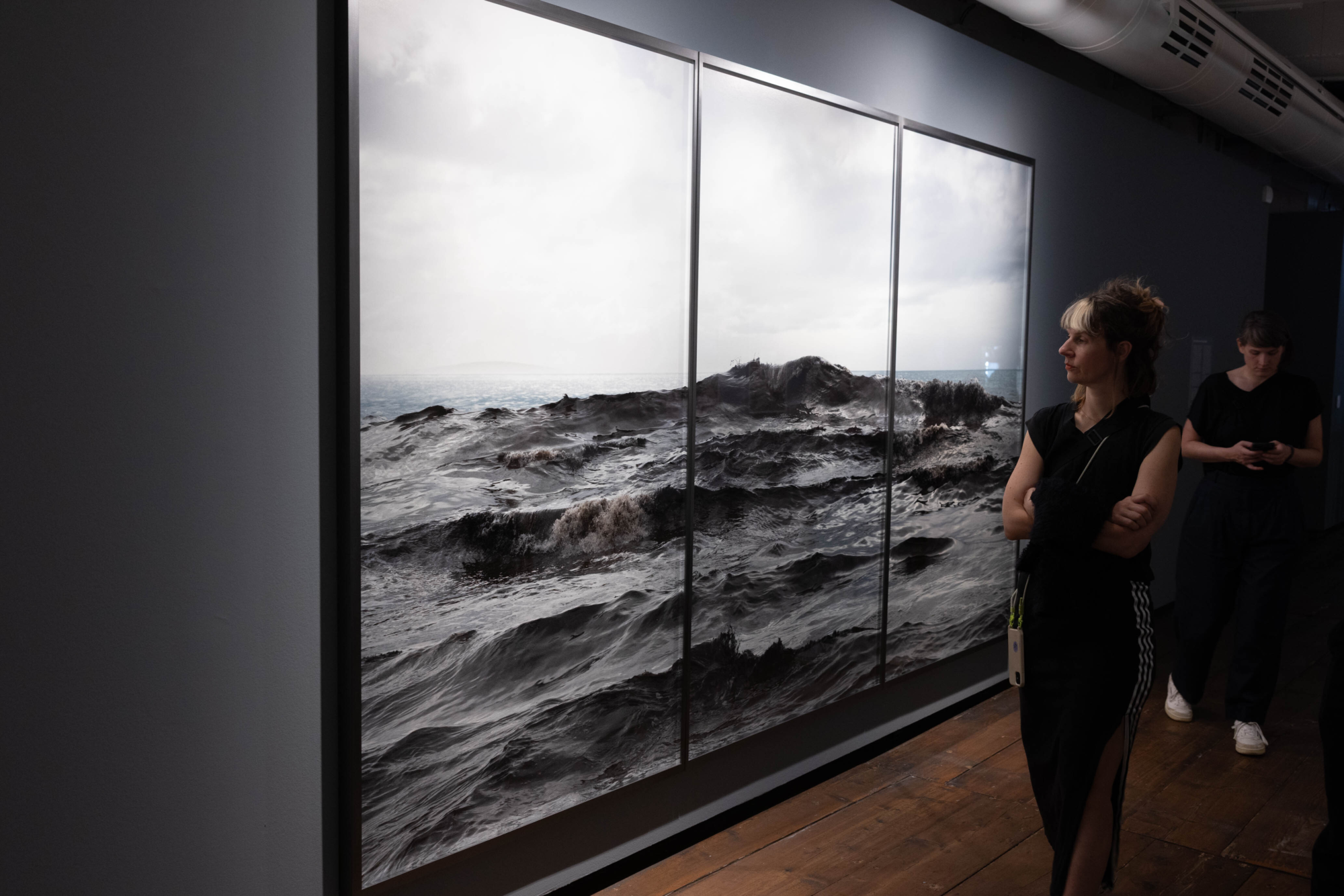 Frau mit blondem Pony, betrachtet Fotografie mit einer riesigen Welle