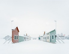 Verschneite Landschaft mit flachen Häusern, die wie Bilderrahmen aufrecht stehen