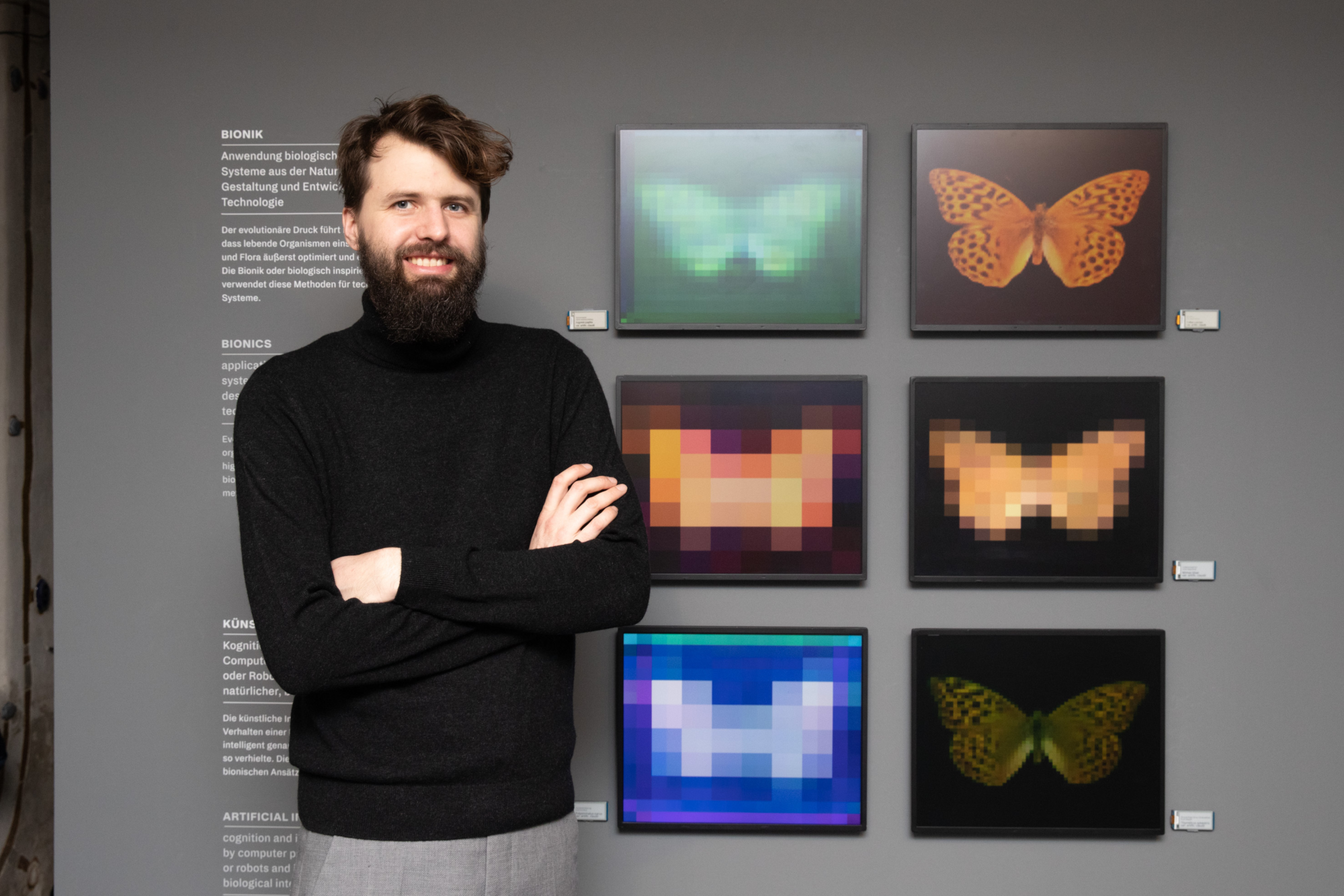Artist poses for picture in front of his art depicting butterflies