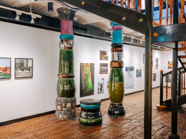 Bild aus dem Inneren des KunstHausWien, das zwei von Hundertwasser entworfene Säulen und einen festen Sitz zeigt