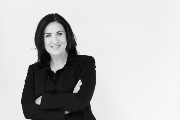 Schwarz-Weiß-Foto der Direktorin Gerlinde Riedl in schwarzer Bluse und mit verschränkten Armen