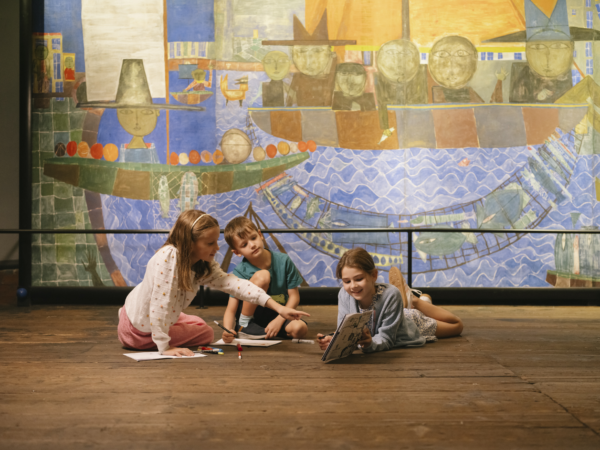 Kinder liegend vor einem Kunstwerk